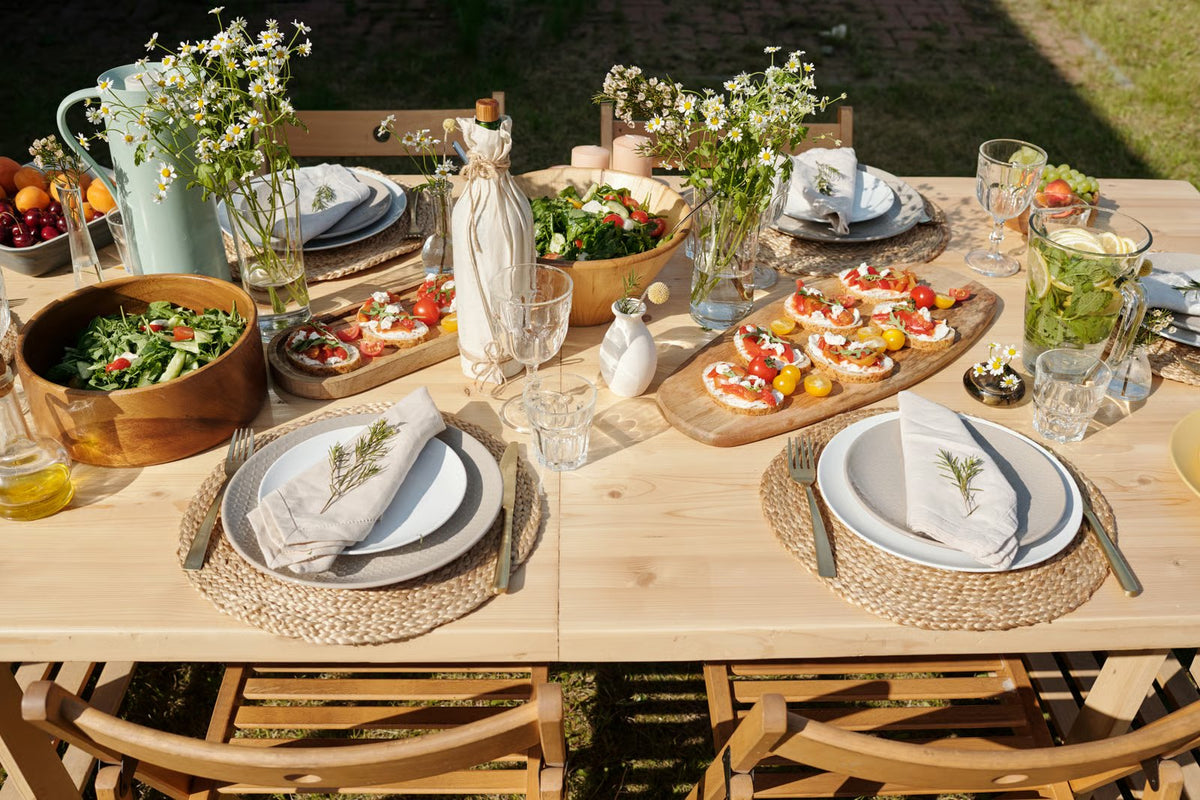 Sommerlich gedeckte Tafel im Garten mit Wiesenblumen und Bruschetta
